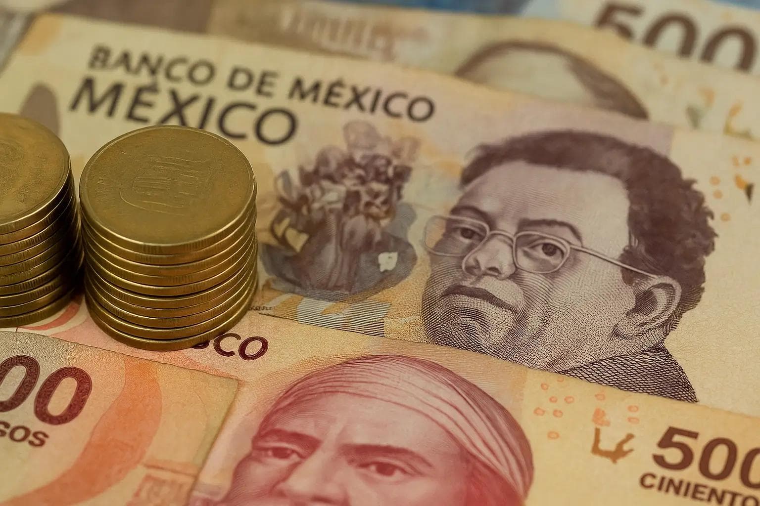 Pesos mexicanos: billetes de 500 pesos y monedas apiladas que representan la economía de México
